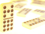 Line of Black and White Dominoes Against White Background with Fallen Dominoes