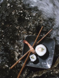 Elegant Sushi and Chopsticks Beside Rushing Water
