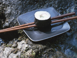 Elegant Sushi and Chopsticks Beside Rushing Water