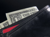 Dollar Bills Sticking out of Black Leather Wallet