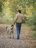 Man Walking a Dog Through Autumn Park
