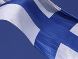 Close-up of the Flag of Finland on White Fabric with a Blue Cross Against Blue Sky
