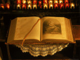 Open Bible and Prayer Candles in Background