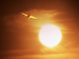 Airplane Flying Above Clouds Into Sun