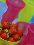 Close-up of Strawberries in Yellow Bowl  Surrounded by Colourful Glasses