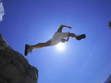 Hiker Leaping Over Rocks