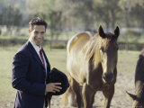 Jockey Standing Next To Two Horses