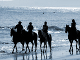 Group of People on Horseback at the Beach