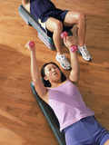 Young Woman and a Young Man Exercising with Dumbbells in a Health Club