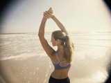 Rear View of a Young Woman Exercising on the Beach