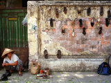 A Shoe Repair Woman Works on a Street