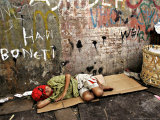 An Indonesian Boy Wearing a Spiderman Mask Sleeps on a Piece of Cardboard