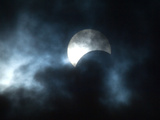 Seen Through Clouds the Sun is Partially Obscured by the Moon During an Eclipse