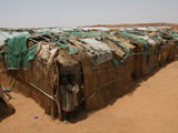 Two Sudanese Boys Stand by Makeshift Huts