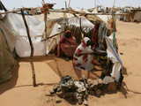 Two Sudanese Women Sit at a Make Shift Hut