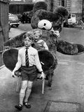 A Boy Gives a Ride to a Little Girl and a 9-Foot Teddy Bear at the Opening of the British Toy Fair