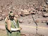 An Injured Pakistani Man Walks on an Earthquake-Damaged Mountain Pass Road