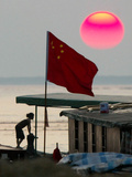 A Girl Rests on a Boat Below the Chinese National Flag