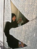 A Family are Seen Through the Shattered Window of Their House