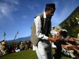 A Devotee Distributes Holy Charms to Fellow Devotees at a Forest Shrine of Miyan Peer