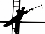 Silhouetted against the Bright Morning Sun  a Window Cleaner Stretches to Clean a Spot