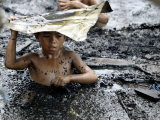 A Filipino Boy Wades Through Murky Waters