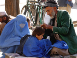 A Mother Watches as Her Child Gets a Haircut in the Center of Kabul  Afghanistan on Oct 9  2003