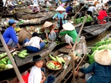 Small Wooden Boats Loaded with Fresh Produce Gather Along a Canal