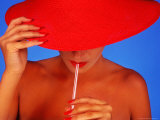 Woman Wearing Red Hat Sipping From a Straw