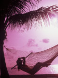Woman Relaxing in a Hammock on the Beach at Sunset