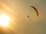 Bright Orange Sunlight with a Parachuter in the Sky