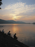 Men Sitting on the Banks of a River Fishing