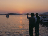 People Standing on the Coast Waving at a Boat at Sea