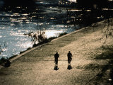 Cyclists on Cobbled River Banks of Tiber River  Rome  Italy