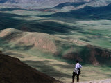 Trekker Looking Out at Hills and Meadows Outside of Kochkor  Kyrgyzstan