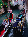 Gondola with Passengers Gliding Through Narrow Canal  Venice  Italy