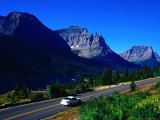 Car Driving on Road with Mountain Range Glacier National Park  Montana  USA