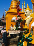 People Making Offerings Amongst the Statues of Deities at the Base of Shwedagon Paya  Myanmar