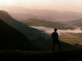 Lake District Dawn Rises in a Lakeland Pass Watched by Man in Hat