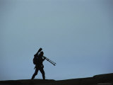 Photographer Carrying a Tripod in Silhouette at Twilight