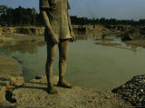 Gold Miner Standing Next To Runoff Pond Laced with Mercury and Cyanide
