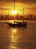 Silhouetted Sailboat at Sunrise with San Diego Skyline in Distance