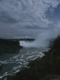 Distant View of Mist-Shrouded Niagara Falls Under a Cloudy Sky