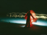 Time Lapse Photo of Man Draped in Red Cloth and Squiggly Lights