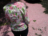 Real Fallen Cherry Blossoms Blend with a Floral Blouse