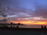 Twilight View of Young Cubans Sitting on City's Seawall