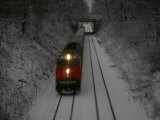 Train Approaches Through Falling Snow at Dusk