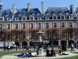 People Relaxing Around Fountain in Place Des Vosges