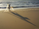 Woman Tending to Fishing Net on Beach Near Mui Ne
