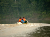 Tourists Looking for Wildlife on River at Dusk